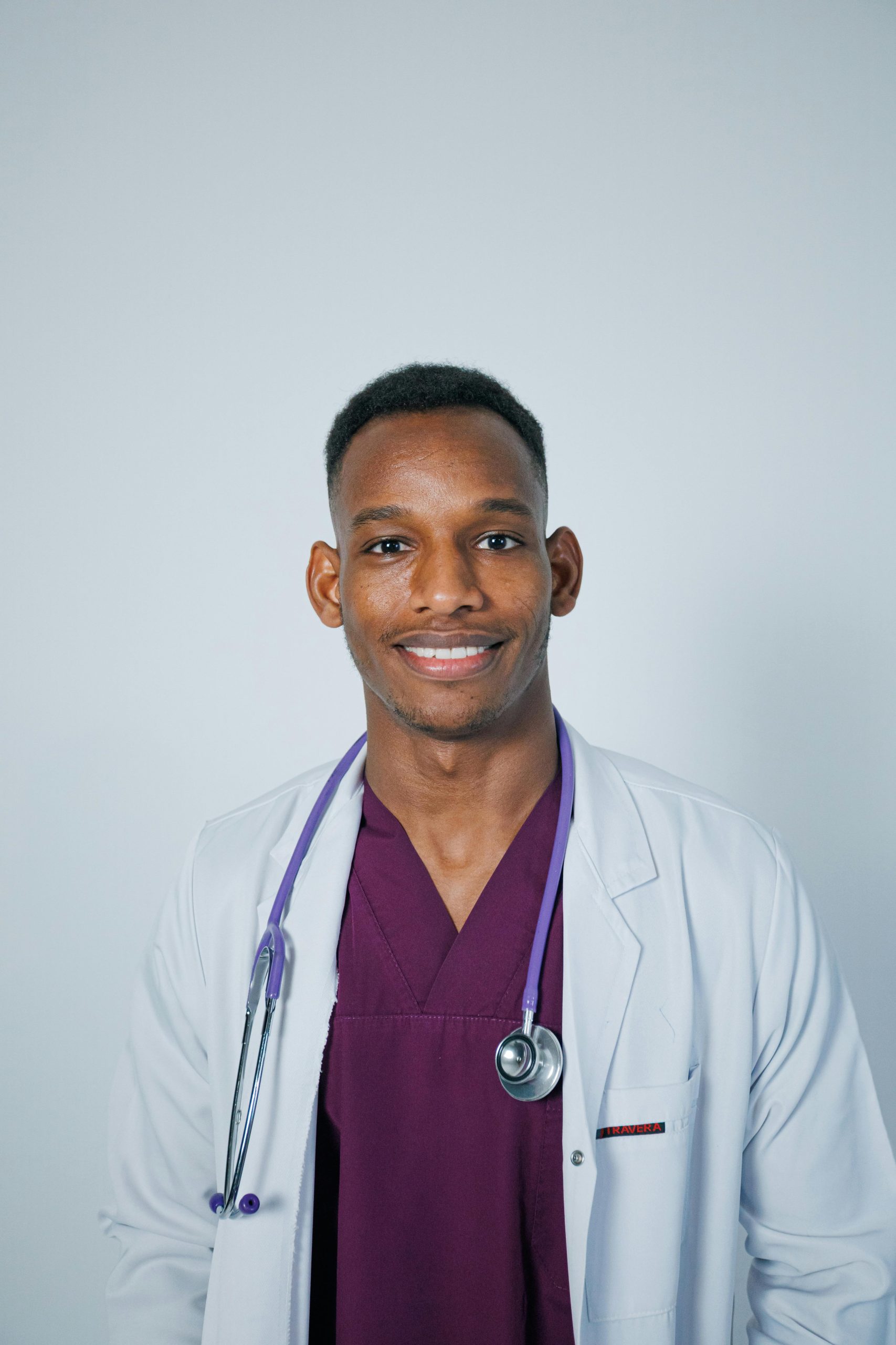 Smiling doctor in lab coat with stethoscope, symbolizing healthcare and professionalism.
